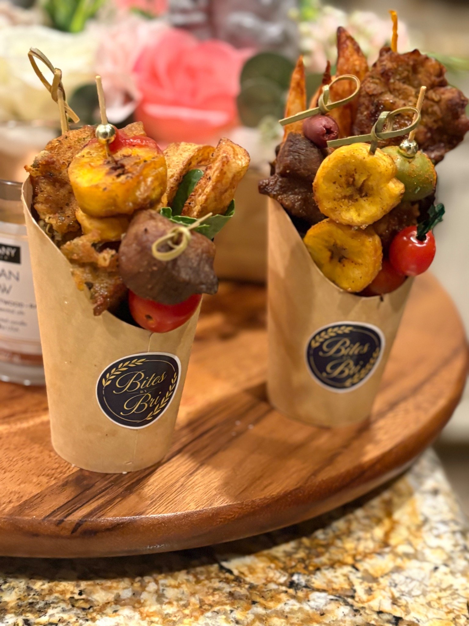Two savory cups with plantain slices and skewered bites.