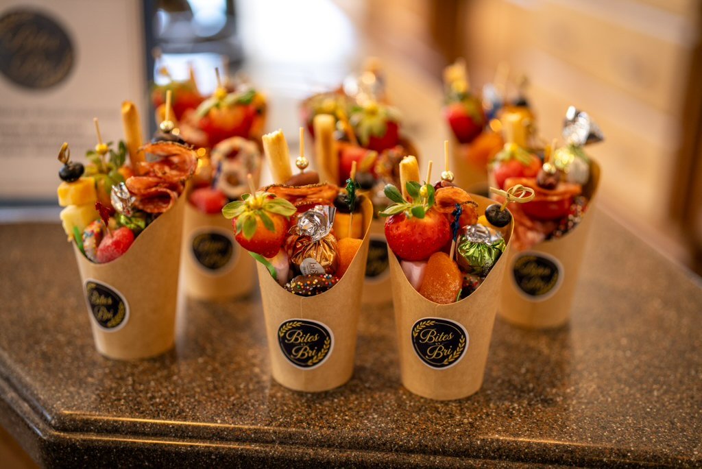 Bites by Bri cups filled with fruit, cheese, savory bites, and sweet accents.